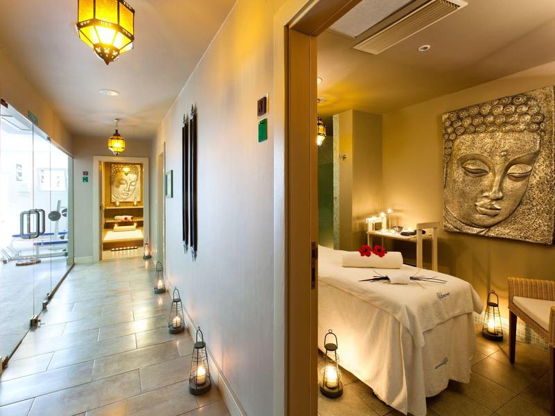 Intérieur d'un espace spa moderne avec table de massage et décoration bouddhiste apaisante.