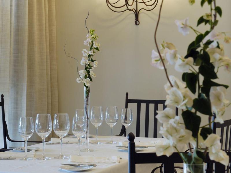 Elegancka jadalnia z białymi obrusami i świecznikami na ścianie.