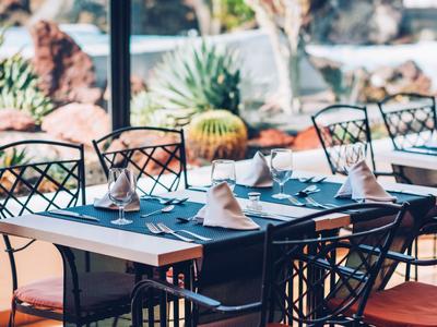 Elegancko nakryty stół z złożonymi serwetkami i szklankami w jasnej restauracji.