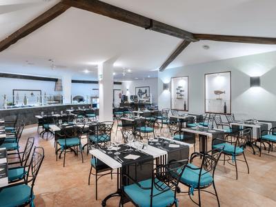 Nowoczesna, jasna jadalnia z niebieskimi krzesłami i czarnymi stołami w hotelu.