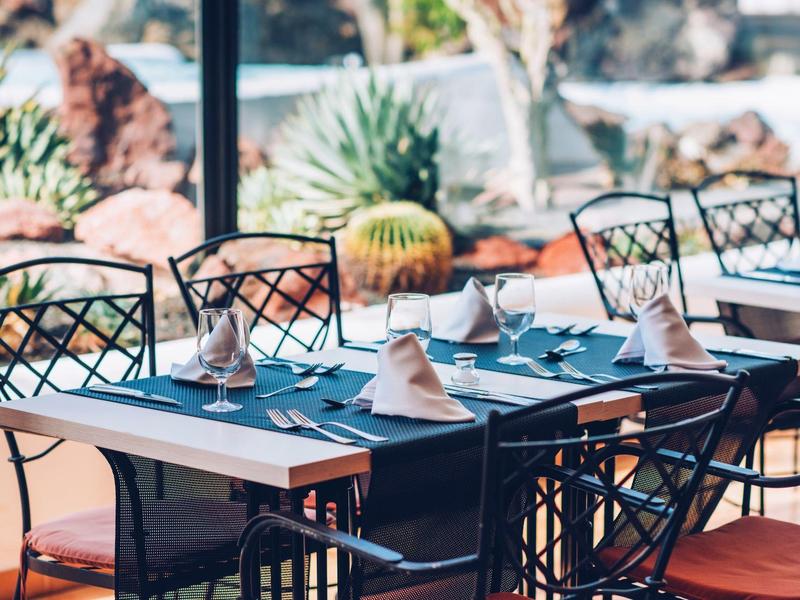 Elegancko nakryty stół z złożonymi serwetkami i szklankami w jasnej restauracji.