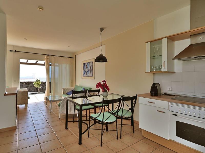 Nowoczesna kuchnia i jadalnia z białymi szafkami i widokiem na salon.