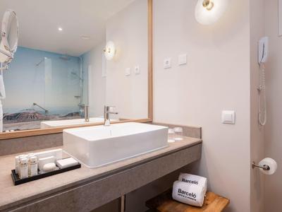 Modern bathroom vanity with sink, large mirror, and decorative beach image.