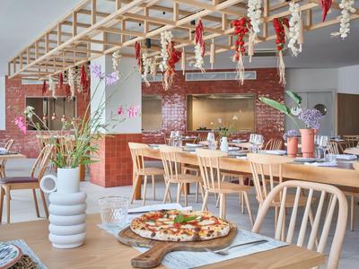 Modern restaurant with wooden furniture and rustic decor, pizza on the table