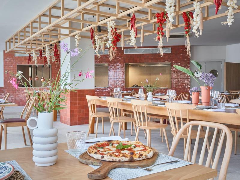 Modern restaurant with wooden furniture and rustic decor, pizza on the table