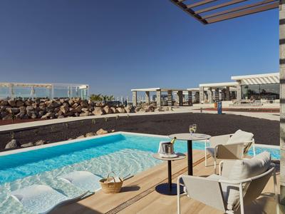 Moderner Poolbereich mit Liegestühlen und Getränken an einem sonnigen Tag