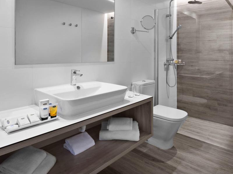 Bagno moderno con lavabo, WC e doccia walk-in dal design elegante.