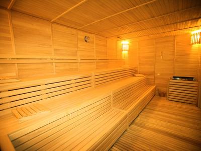 Heldere en ruime sauna met houten banken en warm licht.