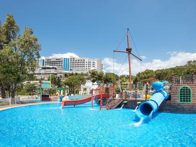 Waterpark met piratenschip speeltuin en blauwe glijbaan voor hotel bij heldere lucht