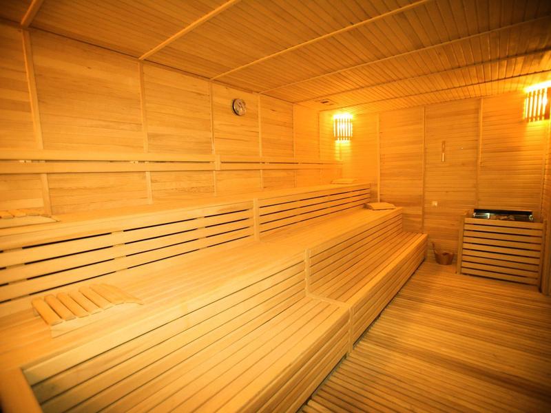 Heldere en ruime sauna met houten banken en warm licht.