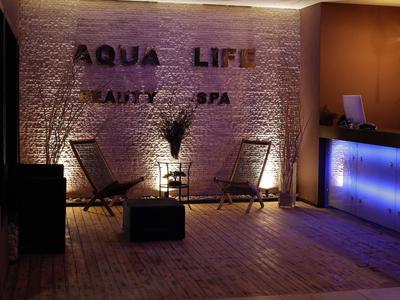 Een ontspannen spa-wachtgebied met stoelen en een verlichte receptie.