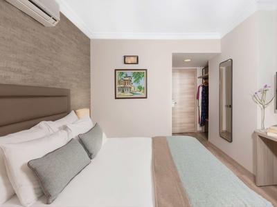 Modernes Hotelzimmer mit großem Bett, bequemen Kissen und minimalistischer Einrichtung.