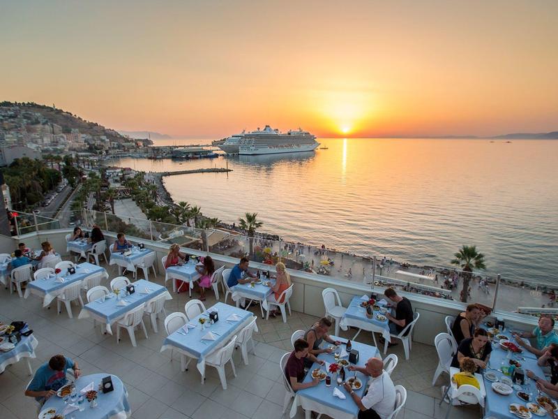 Kolacja na tarasie z widokiem na morze, statek wycieczkowy i zachód słońca