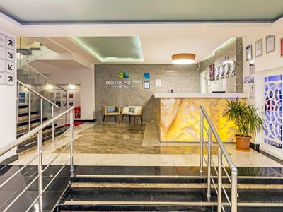 Ingresso dell'hotel con reception, area salotto e scale, design moderno e accogliente.