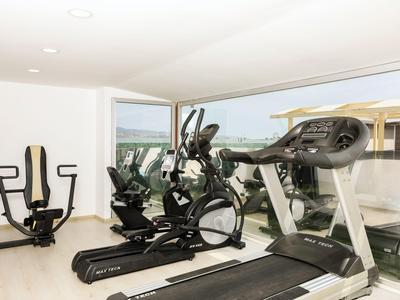 Moderner Fitnessraum mit Laufbändern und Fahrradergometern mit Blick nach draußen.