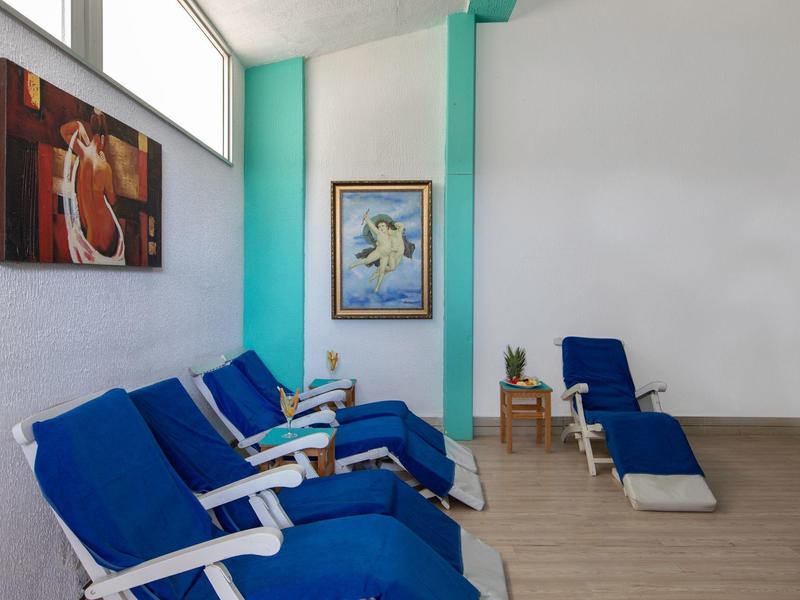 Diverse sdraio blu contro una parete bianca con opere d'arte in una stanza luminosa.