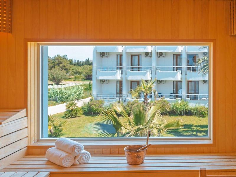 Sauna in legno con vista sul giardino dell'hotel e edificio su più piani