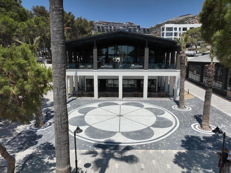 Nowoczesny hotel z dużym tarasem i geometrycznym wzorem na podłodze.