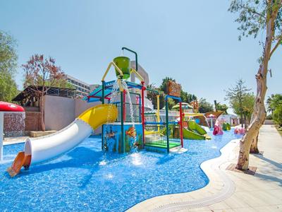 Colorful water playground with slides and splash pools in a sunny holiday resort.