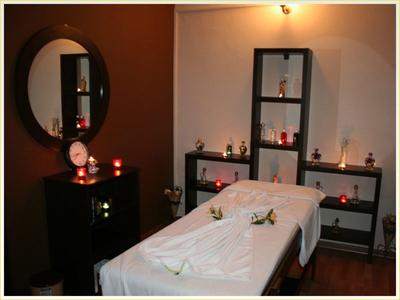 Cozy spa room with massage table, candles, and relaxing lighting.