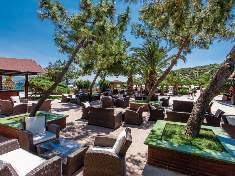 Outdoor terrace with seating and trees on a sunny day at the hotel