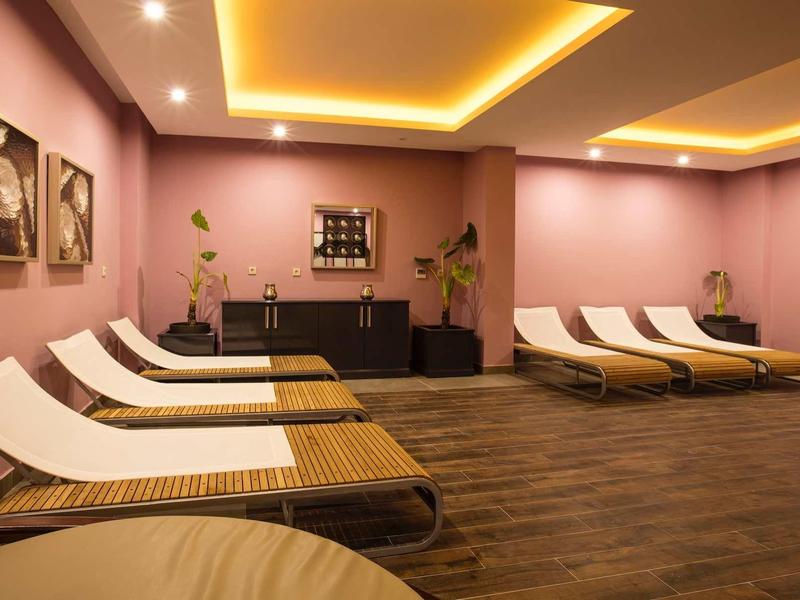 Relaxation room with lounge chairs, soft lighting, and warm-toned decorative wall art.