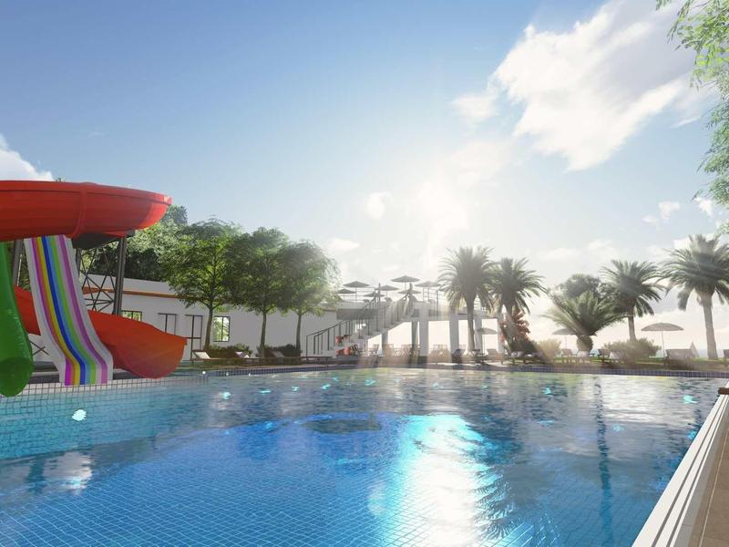 Schwimmbad mit Wasserrutsche, Palmen und Liegestühlen bei sonnigem Himmel.