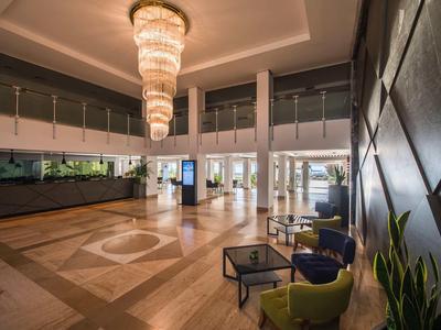 Großer Hotellobby-Bereich mit Kronleuchter, Sitzgelegenheiten und modernem Design.