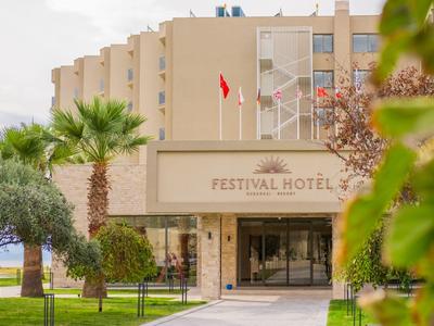 Festival Hotel mit modernem Gebäude, Palmen und Garten im Vordergrund.