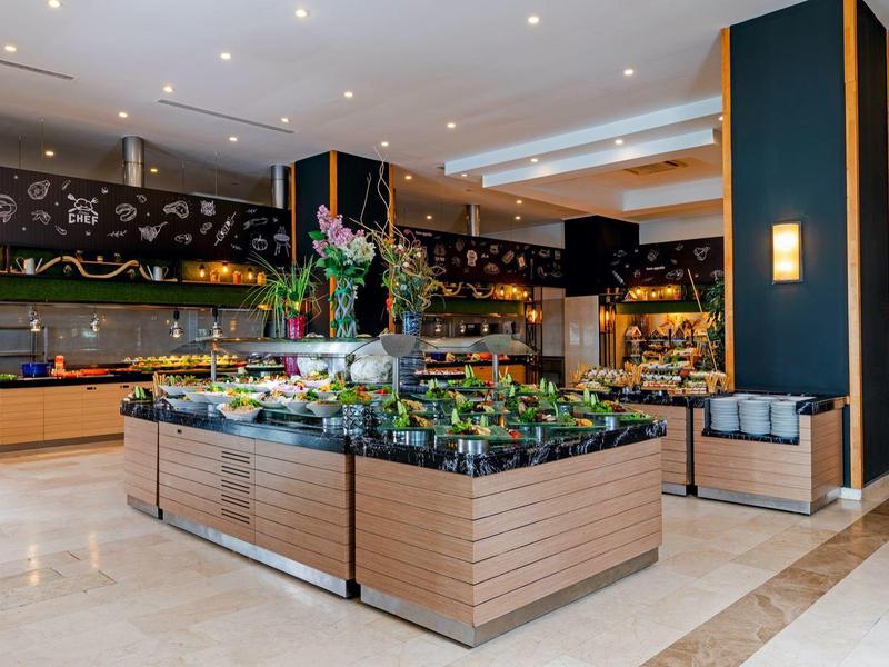 Modern hotel buffet area with a variety of fresh salads and wooden serving stations.