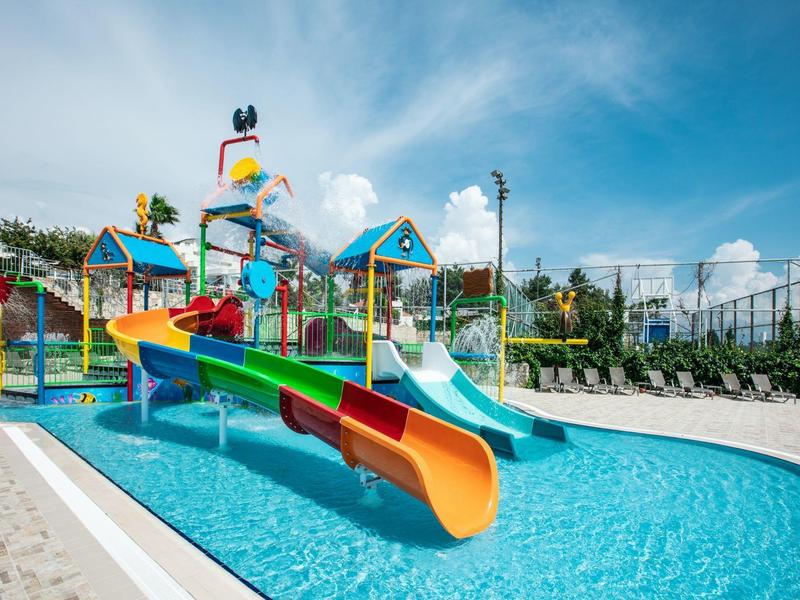 Colorful water slides and pool area with clear blue sky in a water park setting.