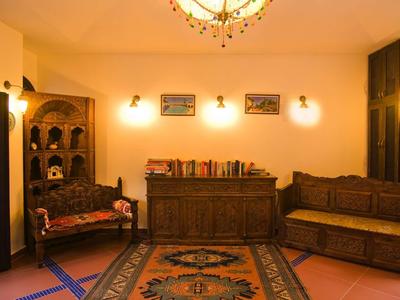 Gemütliches Wohnzimmer mit Holzmöbeln, Teppich in warmen Farben und sanfter Beleuchtung.