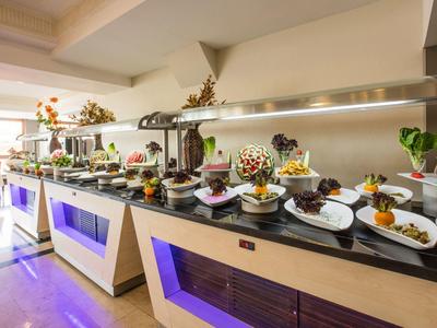 Bufetový stůl s různými jídly v moderní restauraci se světlým interiérem.