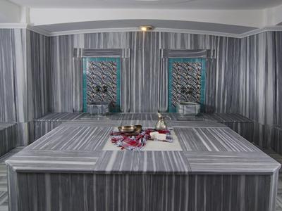 Hammam moderne avec murs en marbre et bassin de lavage central