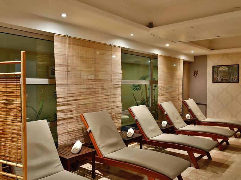 Several padded lounge chairs in a relaxing wellness area with warm lighting.
