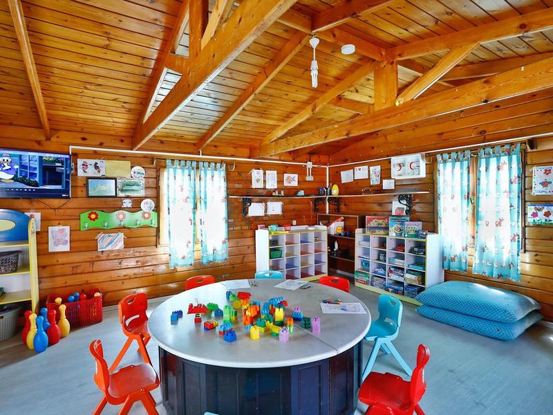 Cozy wooden room with play table and colorful chairs in a vacation rental.