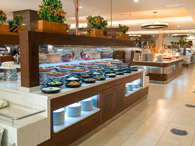 Postazione buffet con vari piatti in un moderno ristorante d'hotel.