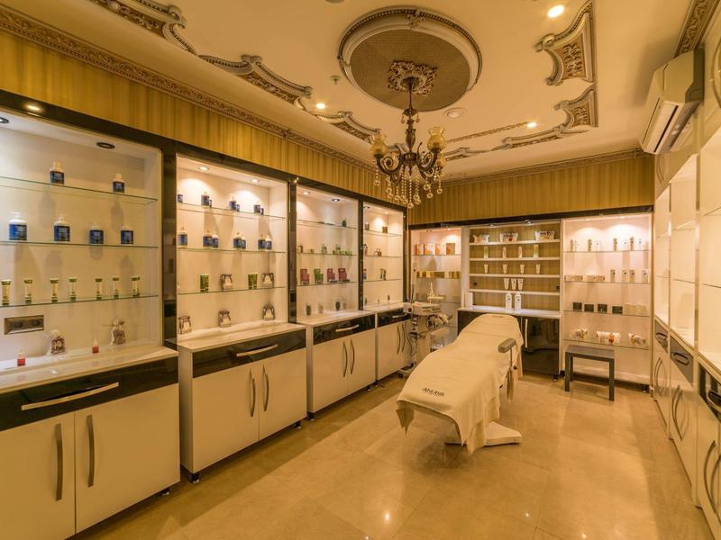 Elegante sala spa con lettino da massaggio, prodotti per la cura della pelle di alta qualità e illuminazione calda.