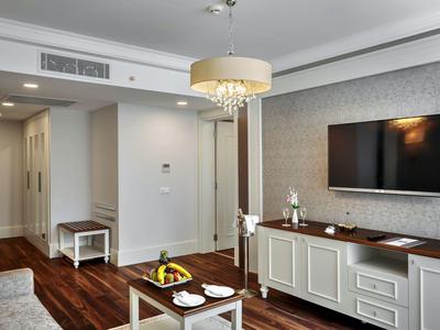 Moderner Wohnraum mit Holzfußboden, Wand-TV, weißem Sideboard und kleiner Sitzbank im Flur.