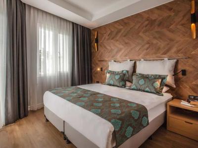 Habitación de hotel moderna con cama doble y diseño de pared de madera.