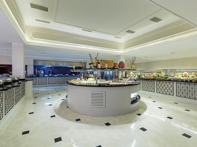 Großer, moderner Buffetraum mit zentraler Insel, hellem Marmorboden und indirekter Deckenbeleuchtung.