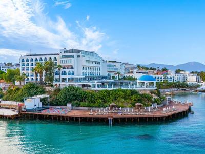 Luxushotel an der Küste mit Pool und direktem Zugang zum Meer bei sonnigem Wetter.