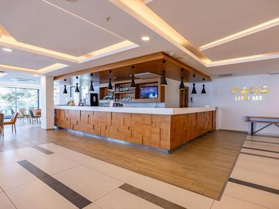 Moderner Hotelbarbereich mit hölzernen Thekenfront und gemütlichen Sitzgelegenheiten.