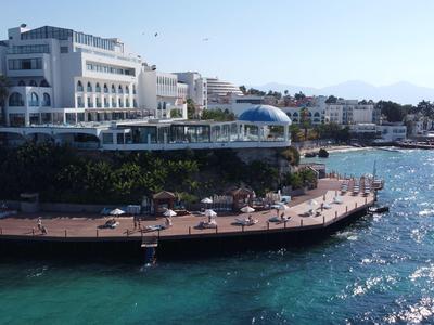 Promenade mit Sitzbereichen entlang der Küste vor Hotels bei sonnigem Wetter