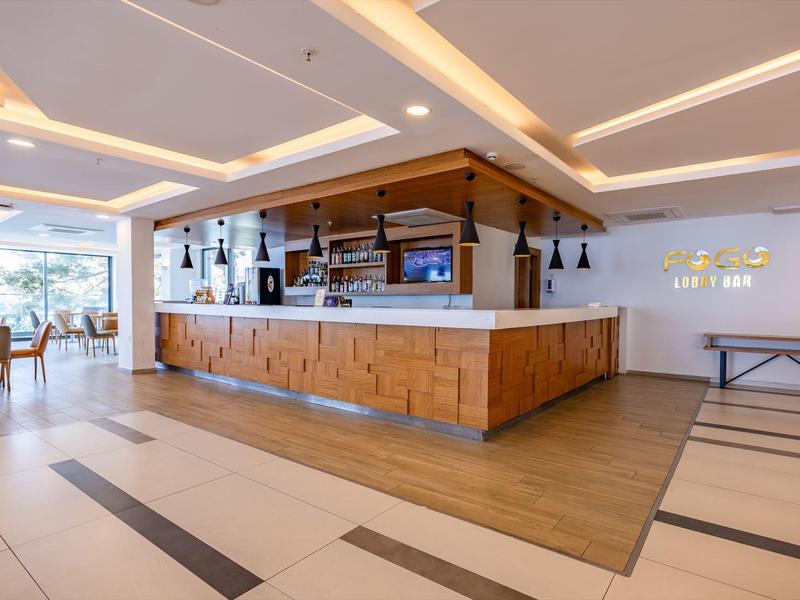 Moderner Hotelbarbereich mit hölzernen Thekenfront und gemütlichen Sitzgelegenheiten.