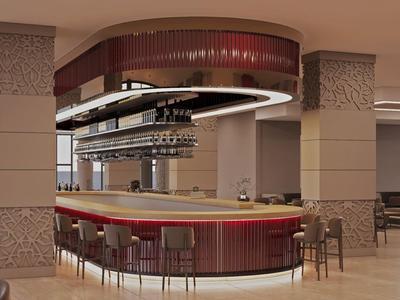 Bar d'hotel moderna con bancone rotondo, posti a sedere e illuminazione elegante.