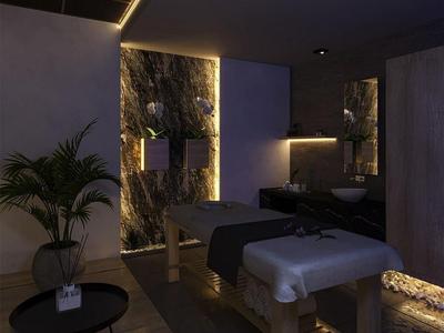 Stanza benessere scura con lettini da massaggio, piante e illuminazione indiretta d'atmosfera.