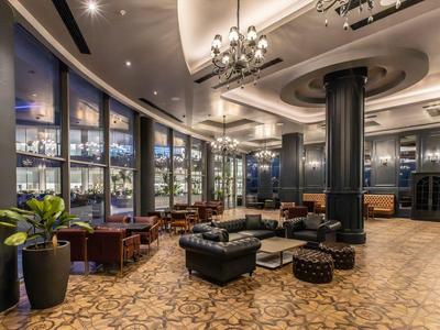 Area lounge elegante dell'hotel con comodi posti a sedere e illuminazione ambientale.