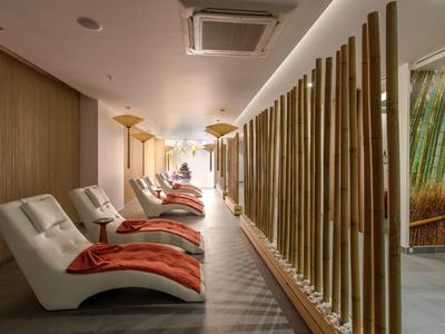 Chaises longues modernes avec des couvertures rouges dans un spa calme avec des éléments en bois et bambou