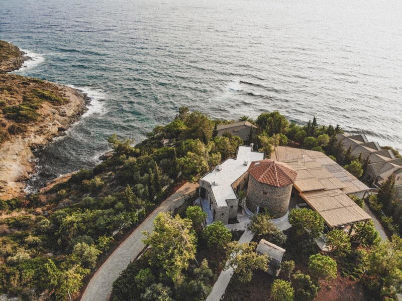 Una villa costiera appartata circondata dal verde vicino all'oceano.